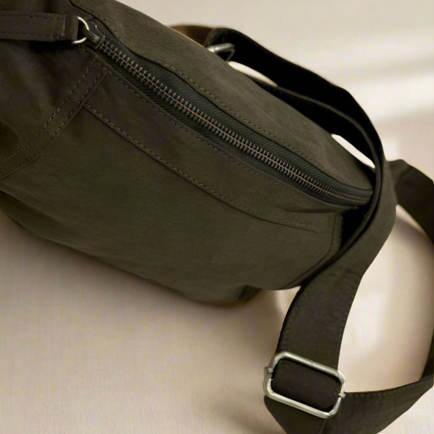 Brown waist bag with a strap on a textured surface