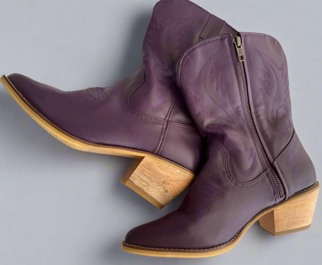Purple cowboy boots with wooden soles on a white background