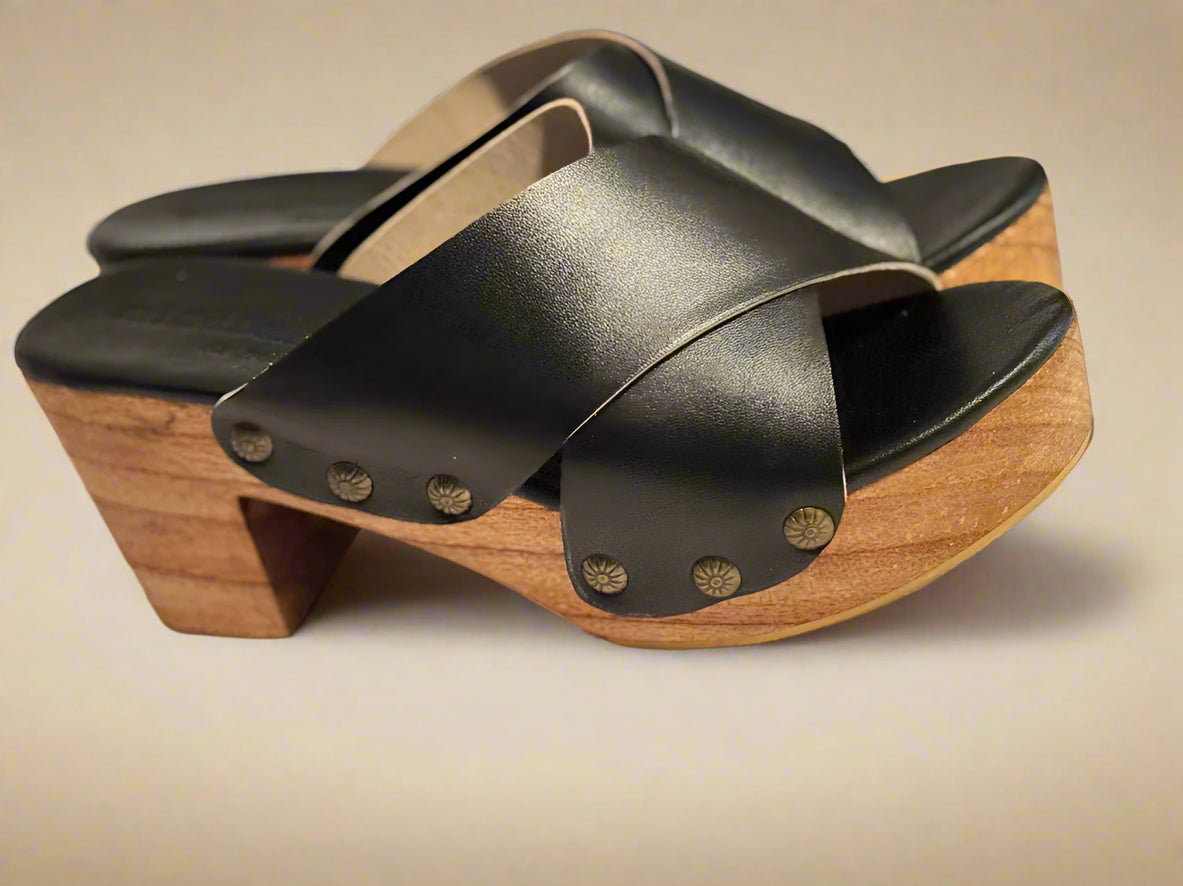 Black leather clogs with wooden sole on a light background
