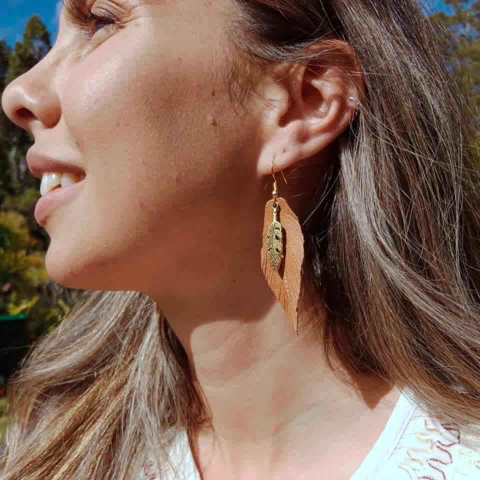 Gold coloured sterling silver earring hooks and brown vegan eco leather cut in the shape of a feather. Embrace cruelty-free fashion with these stunning handmade earrings that add a touch of boho to any outfit. Gold coloured sterling silver hooks and vegan leather. Bohostyle Vegan Handmade Accessories and Jewellery.