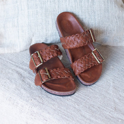 Braided straps, comfortable vegan leather slides with a contoured base. Beautiful vegan shoes handcrafted by artisans in Bali, in fair work conditions. Tan brown sandals, vegan cruelty free and made with eco leather. Eco packaging and fast delivery. beautiful shoes woven with brass buckle. Vegan shoes Australia.