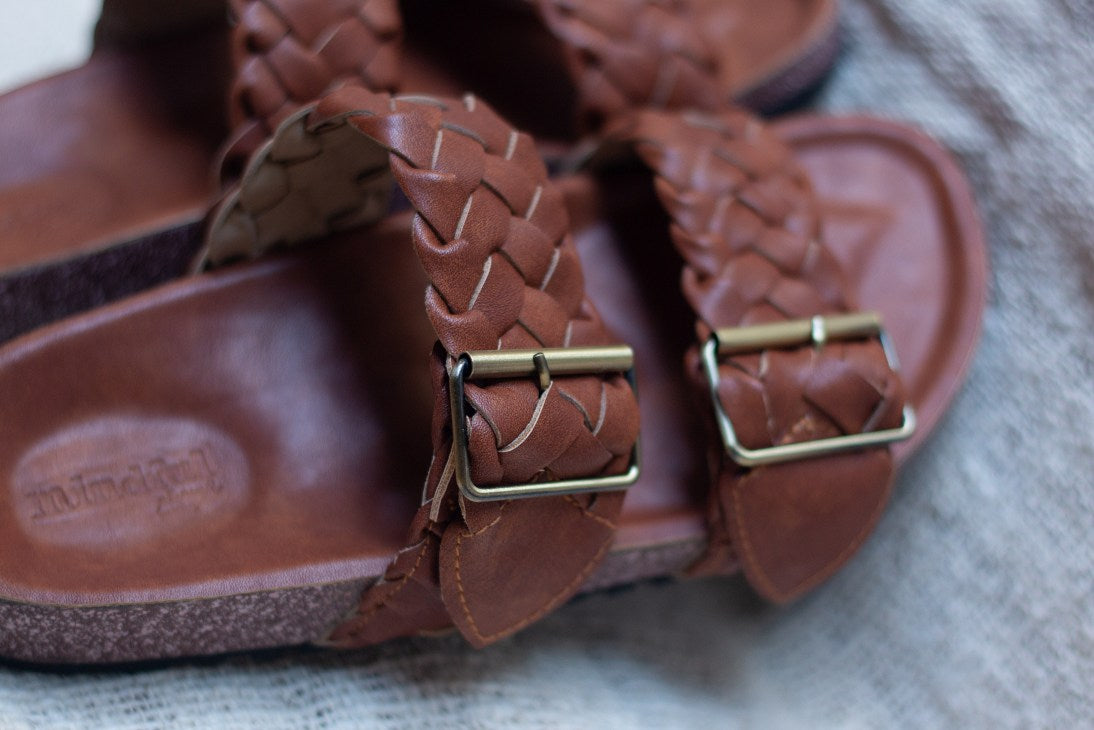Braided straps, comfortable vegan leather slides with a contoured base. Beautiful vegan shoes handcrafted by artisans in Bali, in fair work conditions. Tan brown sandals, vegan cruelty free and made with eco leather. Eco packaging and fast delivery. beautiful shoes woven with brass buckle. Vegan shoes Australia.