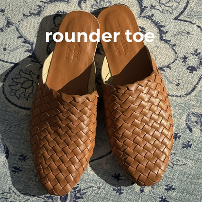 Pair of brown woven sandals on a patterned surface