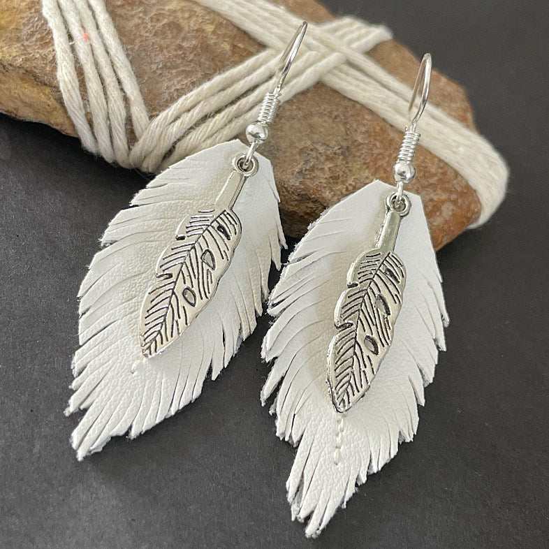 Embrace cruelty-free fashion without sacrificing style with these stunning handmade earrings that add a touch of boho to any outfit. Sterling silver hooks and vegan leather. Keys: Bohostyle Vegan Feather Leather Leaf Boho Handmade Accessories and Jewellery.