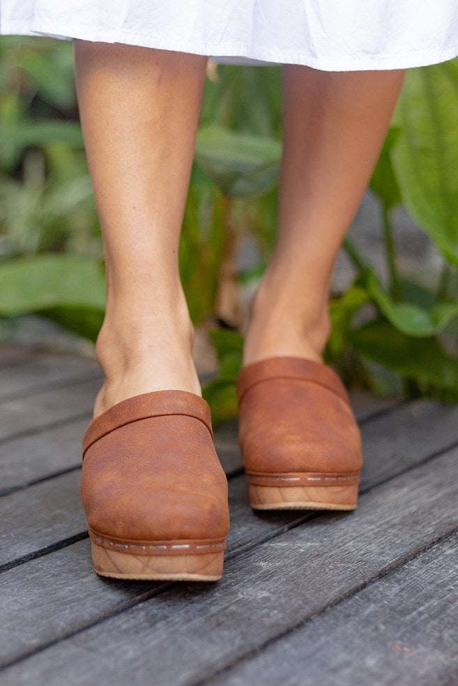 Flat handmade vegan clogs in vegan leather suede for women. Crafted from a single piece of lightweight Bali wood. 5cm and with a padded leather wrapped base for comfort. Vegan Shoes Sydney. Cruelty-free. Small business. Fair work and pay. Vegan sandals mules summer slip on shoes vegan women sandles holiday vintage boho