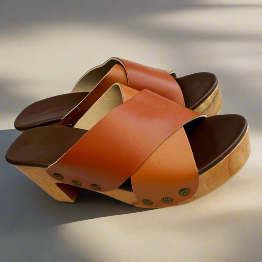 Brown and tan sandals on a light fabric background