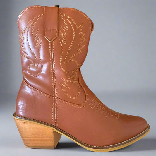 Brown leather cowboy boot with wooden heel on a dark background
