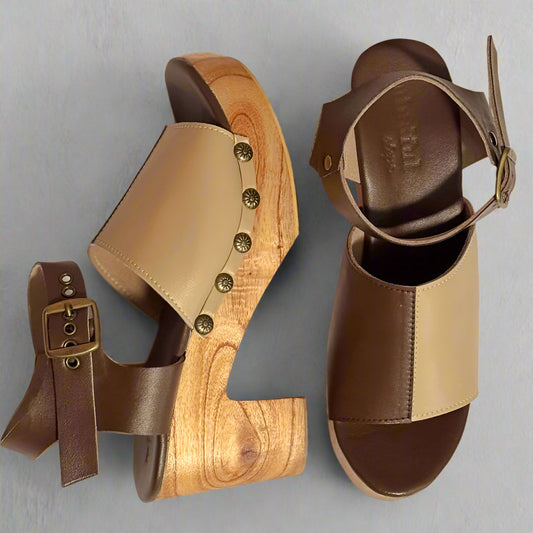 Pair of sandals with wooden sole and brown leather straps on a neutral background